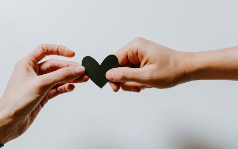 girl making shape of heart with fingers